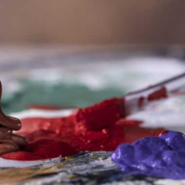 Lähikuva siveltimestä ja maaleista.