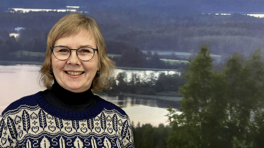Anita Heino järvimaisema taustallaan.